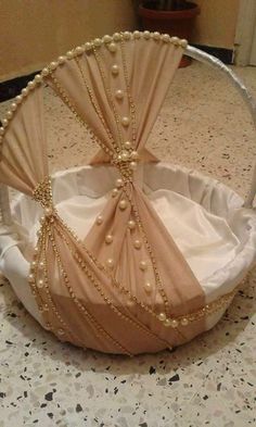 a white basket with pearls on it sitting on top of a table