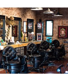 a barber shop with lots of chairs and lights hanging from the brick wall above them