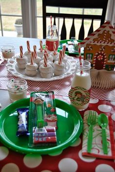 a table topped with plates and cups filled with desserts on top of red and white polka dot paper