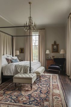 a bedroom with a four poster bed, chandelier and rug on the floor