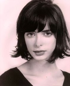 a black and white photo of a woman with bangs