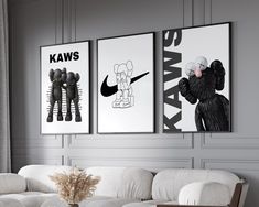 three black and white posters hang on the wall above a couch in a living room