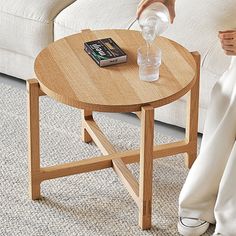 a person sitting on a couch next to a table with a book and water bottle