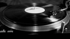 an old record player with a clock on it's turntable, in black and white