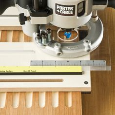 a machine that is sitting on top of a wooden table with a ruler in front of it