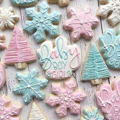 decorated christmas cookies are displayed on a white wooden surface with snowflakes and trees