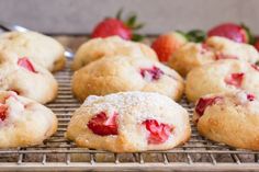 strawberry shortcakes cooling on a rack with powdered sugar