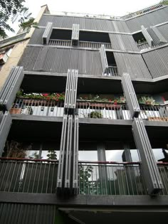 an apartment building with balconies and plants on the balconies