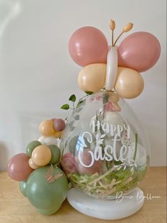 a vase filled with balloons sitting on top of a wooden table next to other decorations