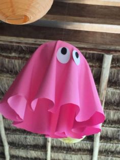 a pink paper umbrella with eyes on it