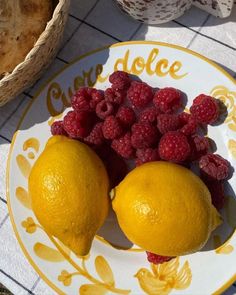 two lemons and raspberries on a plate