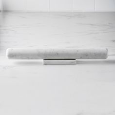 a white marble counter top with a metal object on it