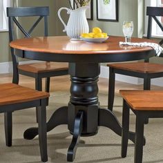 a dining room table with four chairs and a bowl of lemons on the table