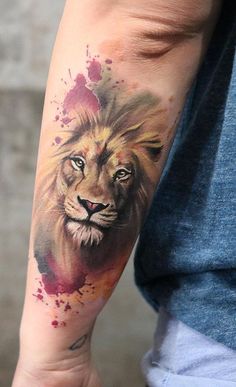 a man's arm with a watercolor tattoo of a lion on the left forearm