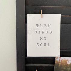 a sign that says, then sings my soul hanging on a wall next to photos