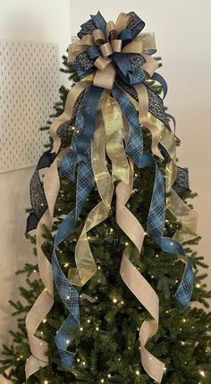 a decorated christmas tree with blue and gold ribbons