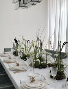 the table is set with white plates and place settings