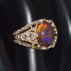 Top Quality Natural Opal And Diamond Ring. This Ring Features A Gorgeous Bombay Dome Design Set With A Huge 2.02cts Natural Opal In Center Surrounded With 0.73cts Of Diamonds Throughout. This Ring Is Meticulously Made With Fine Milgrain And Filigree Work With A Net Like Design In Solid 18k Two Tone Gold . This Ring Has A 100% Natural Earth Mined Opal. The Opal In This Ring Has A Desirable Black / Brown Shade With Vivid Color Play Throughout In Shades Of Red, Orange, Yellow, Green, Etc. The High Quality Natural Diamonds And Opal Are Set Into Solid Heavy 18k White And Yellow Gold. The Oval Cabochon Opal Measures About 11.5mm X 9mm X 5mm. This Is A 100% Natural Solid Opal. No Doublet, Opal And Diamond Ring, Brown Shade, Color Play, Dome Ring, Red Orange Yellow, Brown Shades, Domed Ring, Vivid Color, Natural Earth