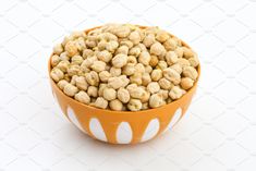 a bowl filled with peanuts on a white background