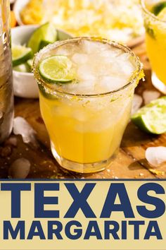 two margaritas sitting on top of a wooden table next to bottles and glasses filled with drinks