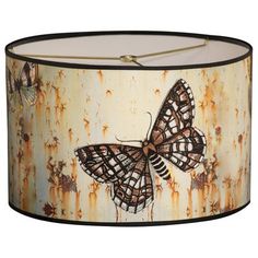 a lamp shade with an image of a butterfly on rusted metal background and black trim