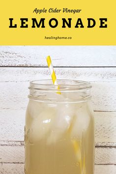 an apple cider vinegar lemonade in a mason jar with a yellow and white striped straw