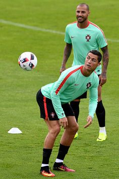 two soccer players in action on the field during a training session with one holding a ball