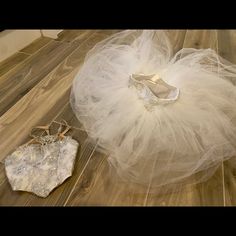 a pair of shoes sitting on top of a wooden floor next to a tulle