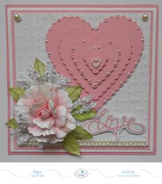 a close up of a card with flowers and a heart on the front, which says love