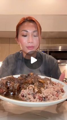 a woman sitting at a table in front of a plate of food with meat and gravy on it