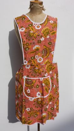 an apron on a mannequin with a flower pattern in orange and yellow colors