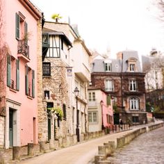 an old street with stone buildings and green shutters