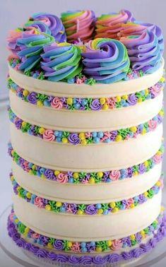 there is a multi layer cake with colorful icing on the top and bottom layers