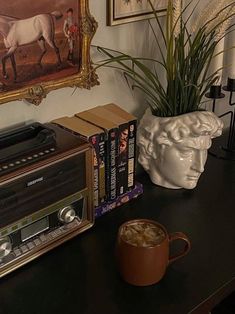 a coffee cup sitting on top of a wooden table next to a radio and some books