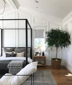 a bedroom with white walls and wood floors