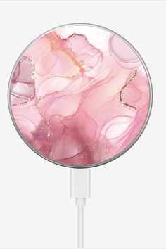 a pink and gold marble pattern is plugged in to a charger with a white cord