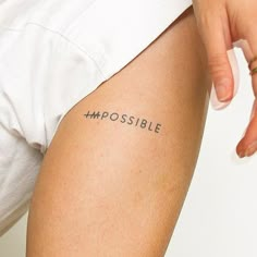 a woman's arm with the word impossible written on it, in black ink