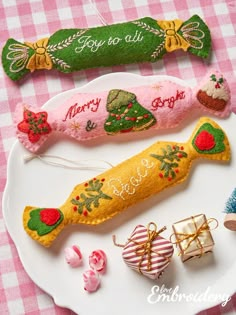 three christmas ornaments on a plate with pink gingham table cloth and candy canes