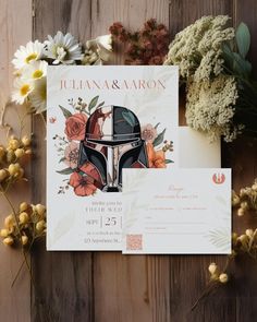 the star wars wedding stationery is laid out on a wooden table with flowers and greenery