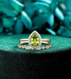 a yellow and white diamond ring sitting on top of a green cushion