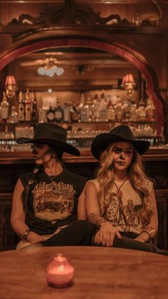 two people sitting at a bar with their faces painted like cowboys and one person wearing a cowboy hat