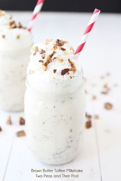 two glasses filled with milkshakes sitting on top of a table