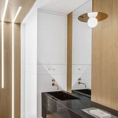 a bathroom with two black sinks and wooden cabinetry in it's center area