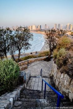 stairs lead down to the beach with city in background