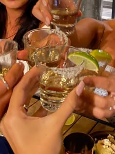 several people are toasting with drinks at a table