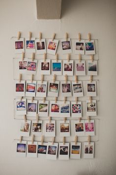 several polaroid photos hung on clothes pegs and pinned to the wall with clothes pins