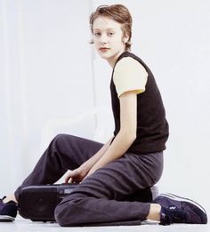 a young boy sitting on the ground with his suitcase