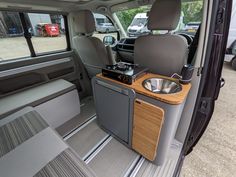 the interior of a vehicle with an entertainment center in the passenger seat and side door open