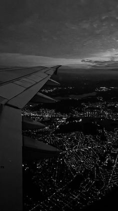 an airplane wing flying over a city at night