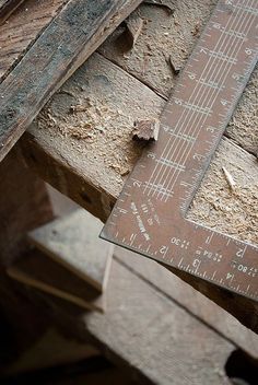 an old wooden ruler sitting on top of a piece of wood